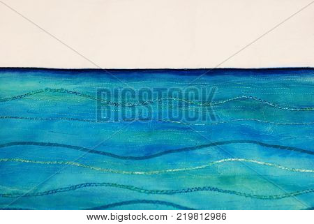 Photo of a beautiful seascape painting on textile using fabric paints in blue and turquoise. Painting stitched using threads and ribbons with a zigzag stitch to create wave shapes. With space for text.