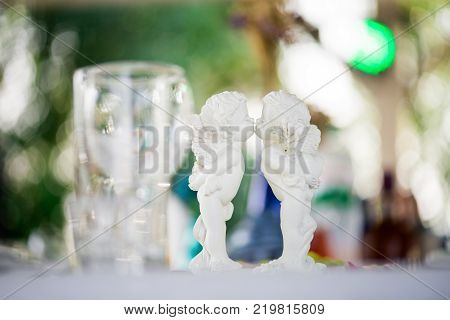 White statuettes of angels on the festive table