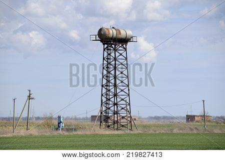 Rusty water tower. An old rustic communal communication.