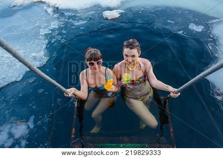 Novokuznetsk, Kemerovo region, Russia - 23 Feb, 2017 : White beaches of Siberia is an enterteiment activity where people playing beach games dressed in bikini in winter. Women in ice hole with drinks