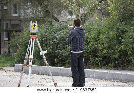 stands next to the level a worker