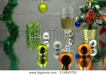 Wine glasses with champagne on a background of Christmas candles and balls and a Christmas tree. New Year's still-life background. 2018