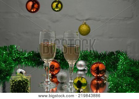 Two champagne glasses Christmas tree Christmas gifts and Christmas balls on black background