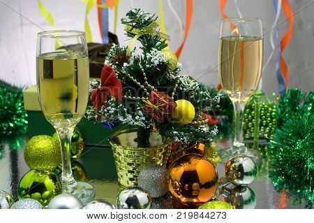 photo of two champagner glasses on glass table with bokeh background