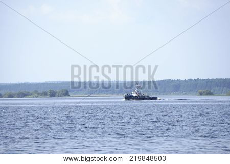 tugboat pushes sand debris along the river