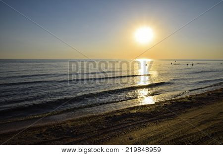 Sea sunset. People bathe in the evening at sunset in the sea