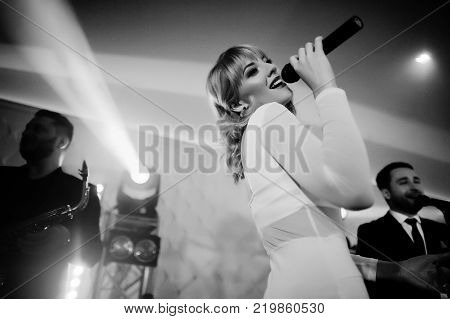 Three Stylish Bearded Man Well Dressed With One Blonde Girl In White Dress Posed. Musician Band Or S