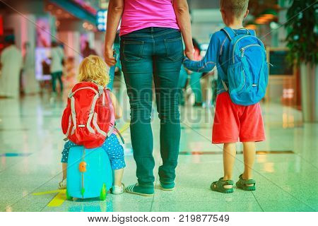 mother and two kids walking in the airport, family travel