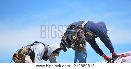 CASPER, WY. MAY 22, 2013. CIRCA: Male roofers at work outdoors on top of a housing project roof.