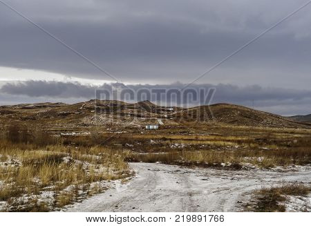 Dramatic dark winter steppe. Thaw. Ice road. City outskirts of the city of Ust-Kamenogorsk Kazakhstan