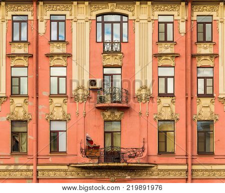 Several windows in a row and balconies on the facade of the urban historic building front view, Saint Petersburg, Russia