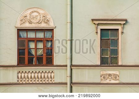 Two different windows in a row on the facade of the urban historic building front view, Saint Petersburg, Russia