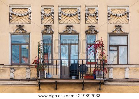 Balcony and several windows in a row on the facade of the urban historic building front view, Saint Petersburg, Russia