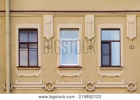 Three windows in a row on the facade of the urban historic building front view, Saint Petersburg, Russia