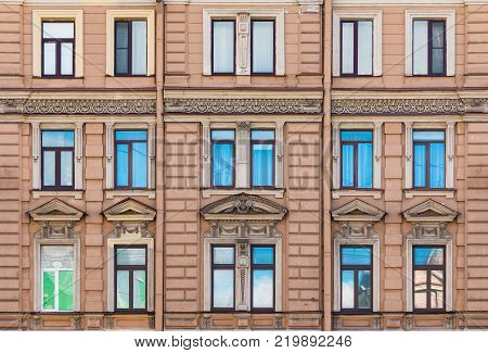 Several windows in a row on the facade of the urban historic building front view, Saint Petersburg, Russia