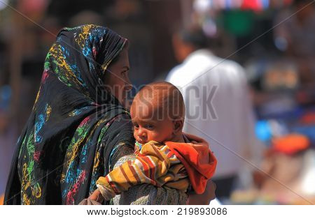 Jodhpur India - October 19, 2017: Unidentified Woman Cuddles A Baby At Sardar Street Market In Jodhp