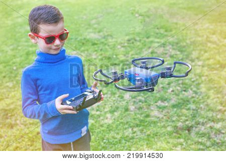 Child playing with drone outdoors at summer day
