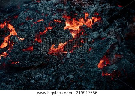 Volcano fire crust. Lava flame on black ash background. Formation geology nature environment. Danger hazard energy concept. Magma textured molten rock surface.