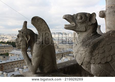 stone sculpture of gargola looking at the city