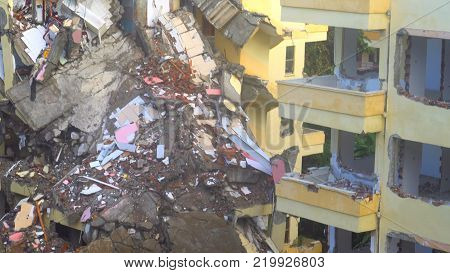 the process of destruction of the old building with heavy machinery.