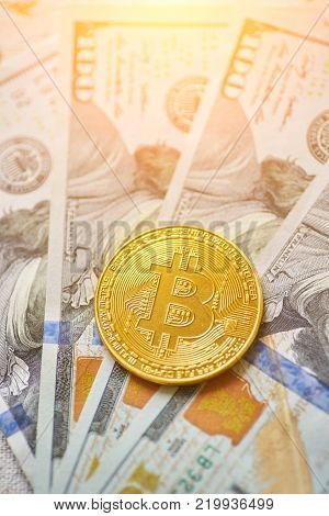 Golden metal bitcoin on dollar bills background