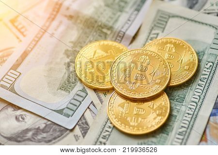 Golden metal bitcoin on dollar bills background