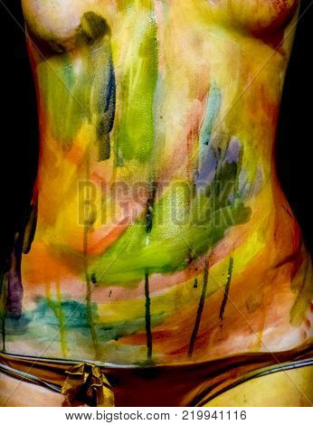 Body art. Drawing on the body. Beautiful girl with painted body watercolors. A white young girl painted the body with paint.