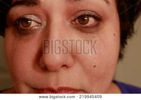 Close up view of ethnic woman with short hair showing crying expression