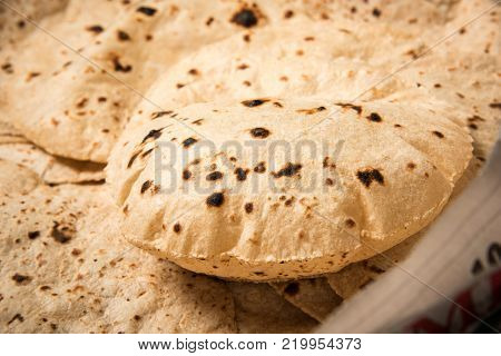 Roti or chapati making machine, selective focus. Indian ready to eat Indian flat bread coming out of machine