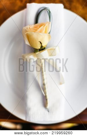 Yellow flower and napkin on the white plate.
