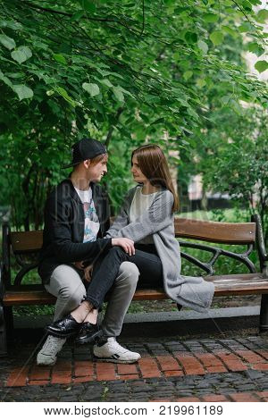 man whisper on her ear lovely words in the park