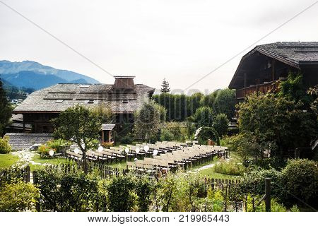 Outdoor wedding ceremony with mountains and buildings in background.