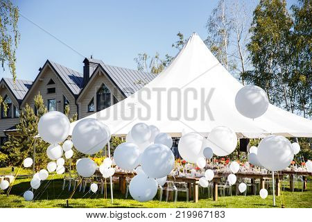 Wedding tent with large balls. Tables sets for wedding or another catered event dinner.