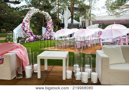 Outdoor wedding ceremony with umbrellas in the forest.