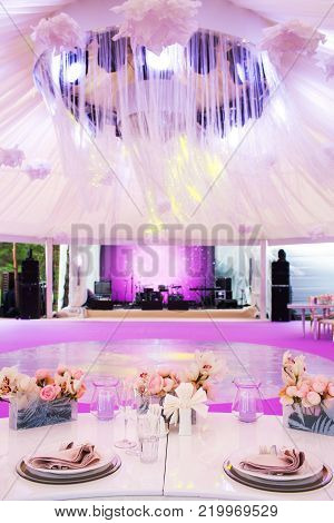 Table set for wedding or another catered event dinner and large white dome.