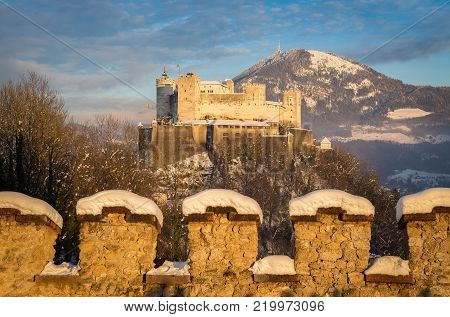 Classic view of famous Festung Hohensalzburg in the historic city of Salzburg illuminated in beautiful golden evening light with blue sky during Christmas time in winter, Salzburger Land, Austria