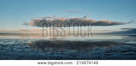 Colourful clouds mirrored in the Wadden Sea at Texel, The Netherlands