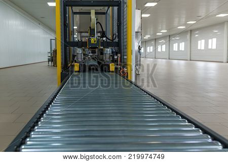 Strapping Machine for Industrail Packaging Line, Modern machine for packaging line in factory, Industrial and technology concept.