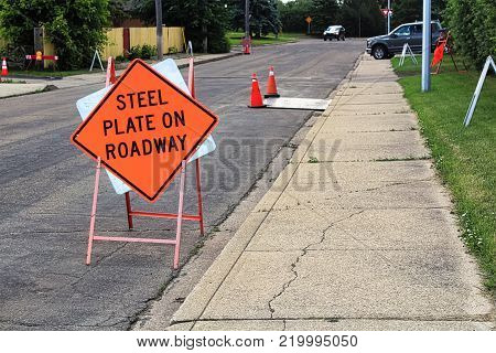 Orange steel plate on roadway construction sign.