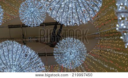 industrial climber sets up Christmas decorations in the shopping centre