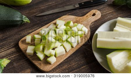 Zucchini Harvest. Slices Farm Organic Zucchini Cubes For Freezing On Woodencutting Board Over Brown 