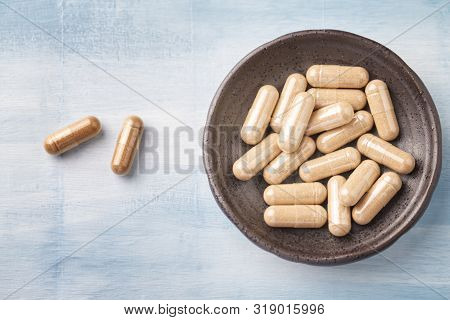 Kudzu Root Capsules. Concept For A Healthy Dietary Supplementation. Bright Wooden Background. Top Vi