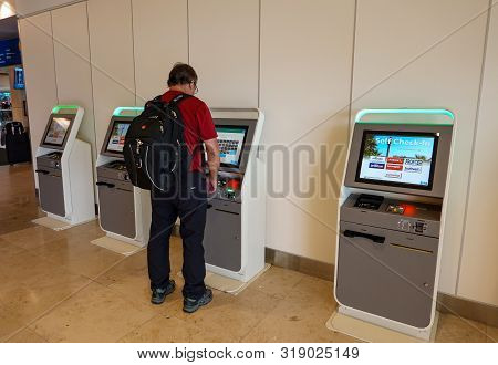 Orlando, Fl/usa-8/22/19: A Man Checking Into A Ticket Kiosk In A International  Airport Terminal  At