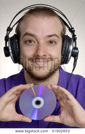 Junge Disk Jockey halten einer Compact Disc.Junger Mann mit Kopfhörer.