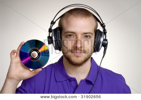 Junge Disk Jockey holding einen kompakte disc.young Mann mit Kopfhörer.