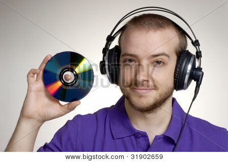 Junge Disk Jockey holding einen kompakte disc.young Mann mit Kopfhörer.