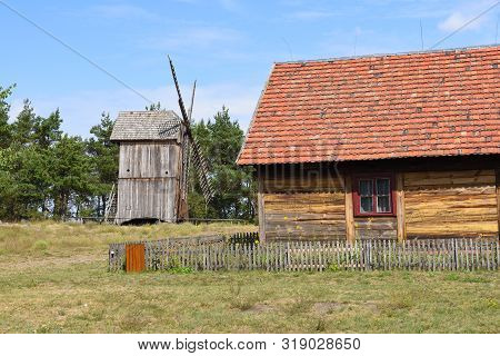 Ethno House With Wooden Windmill In Open-air Museum, Polish Folk Culture. Poland, Europe