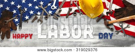 US American flag with work tools on worn white wooden background. For USA Labor day celebration. With Happy Labor Day text.
