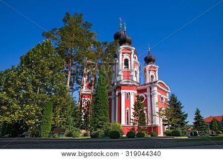 Orthodox Curchi Monastery In Moldova With The Sun Shining At The Crosses, Green Trees And Blue Sky