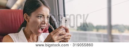 Angry crazy Asian woman upset at mobile phone problem not working or texting upset to somebody over smartphone 5g internet during work commute train ride panoramic banner.